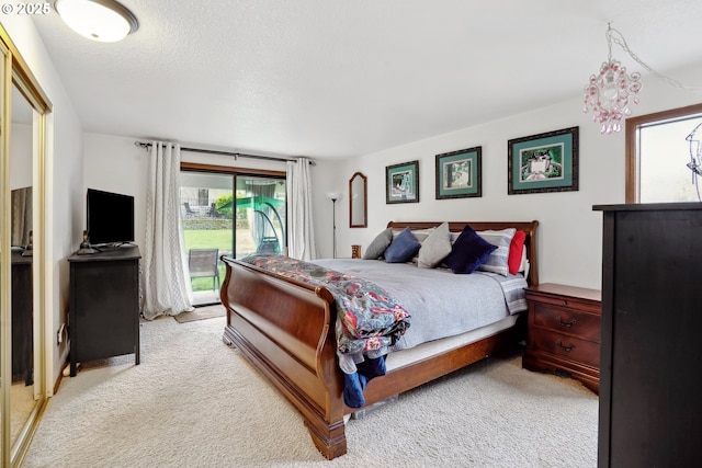 bedroom with light carpet, access to exterior, and a textured ceiling