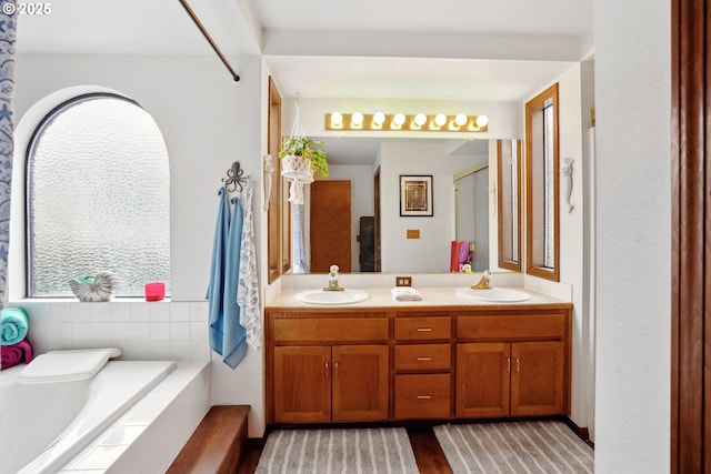 full bath with double vanity, a relaxing tiled tub, an enclosed shower, and a sink