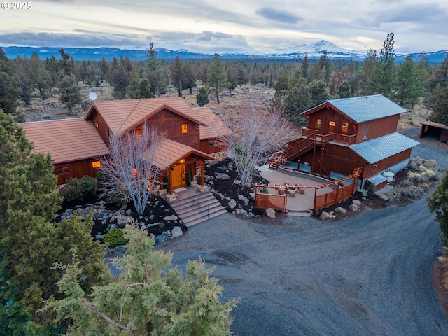 67775 Cloverdale Rd, Sisters, OR 97759 - view of front of house featuring a view of trees, stairway, a mountain view, a metal roof, and covered porch