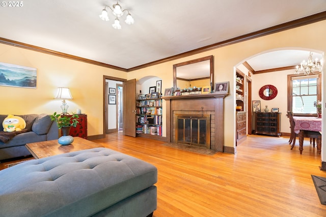 2406 SE 30th Ave, Portland, OR 97214 - living area featuring a chandelier, arched walkways, wood finished floors, a fireplace, and crown molding