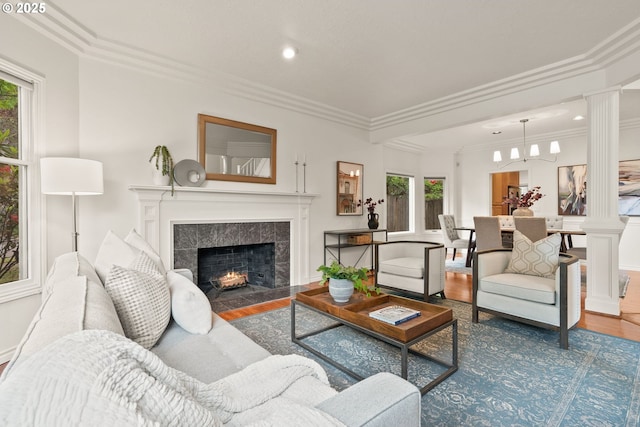 13460 Snowberry Ct, Lake Oswego, OR 97035 - living area featuring decorative columns, wood finished floors, a tile fireplace, healthy amount of natural light, and ornamental molding