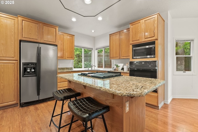 13460 Snowberry Ct, Lake Oswego, OR 97035 - kitchen with appliances with stainless steel finishes, light wood-type flooring, a sink, a kitchen bar, and recessed lighting