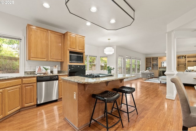 13460 Snowberry Ct, Lake Oswego, OR 97035 - kitchen with appliances with stainless steel finishes, decorative columns, recessed lighting, light wood-style floors, and light stone counters