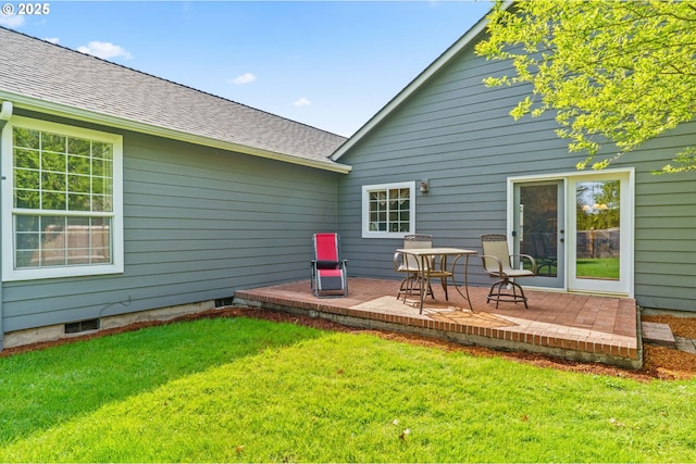 back of property featuring a patio area, roof with shingles, and a lawn