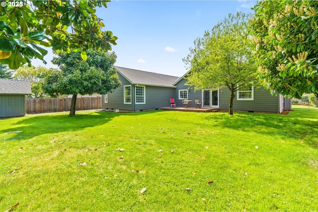 back of house featuring a lawn, fence, and crawl space