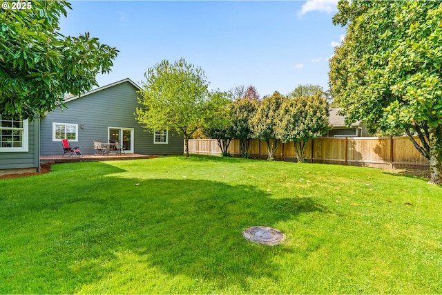 view of yard with a wooden deck and a fenced backyard