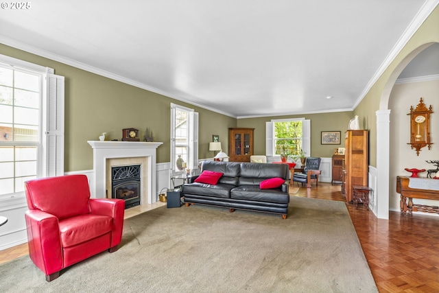 living area with ornamental molding, a fireplace, and arched walkways