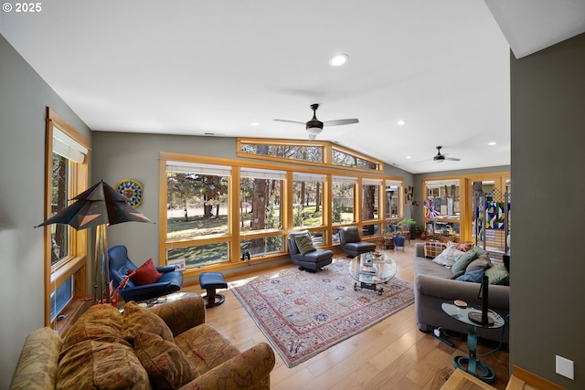 living room with lofted ceiling, wood finished floors, ceiling fan, and plenty of natural light