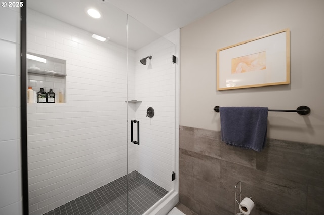 full bath featuring tile walls and a stall shower