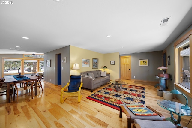 living area featuring visible vents, light wood-type flooring, and recessed lighting