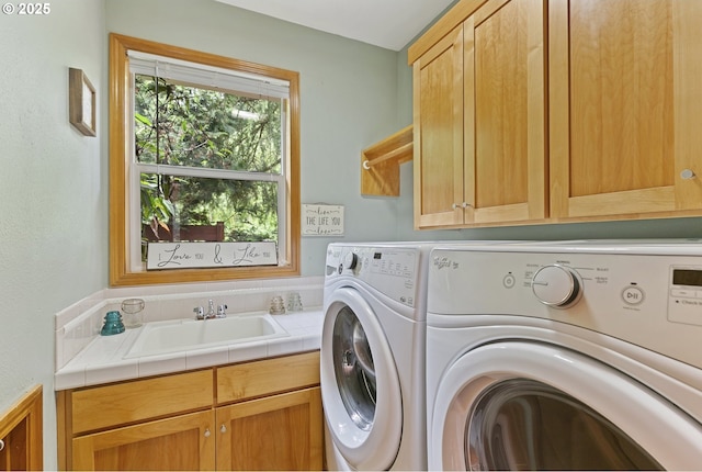 clothes washing area with cabinet space and independent washer and dryer