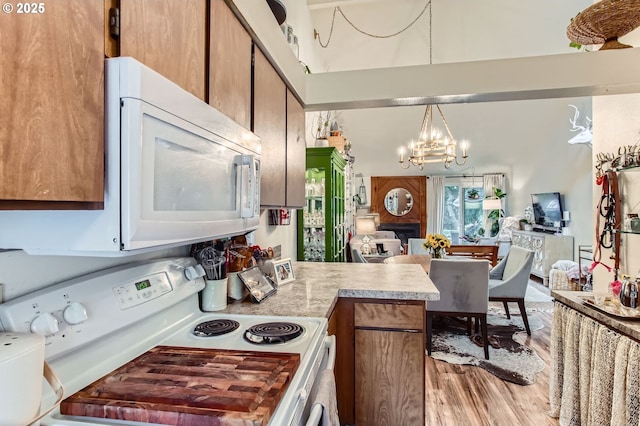 15940 SW 88th Ave, Tigard, OR 97224 - kitchen featuring white appliances, light wood-style floors, a chandelier, open floor plan, and brown cabinets
