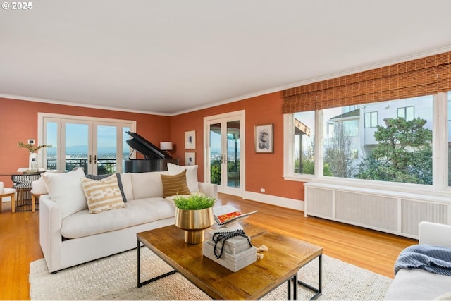 living room with radiator, crown molding, french doors, and hardwood / wood-style floors