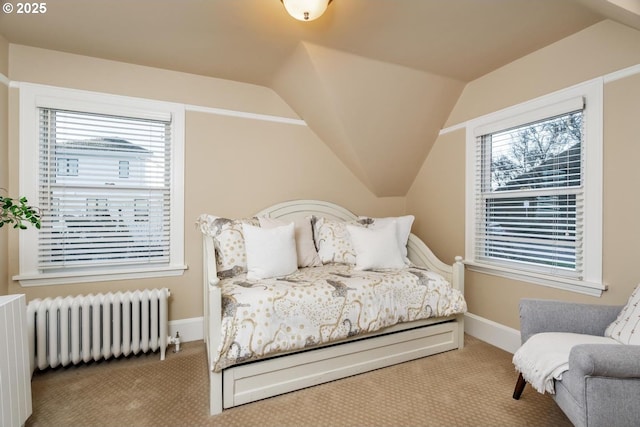 carpeted bedroom featuring lofted ceiling and radiator