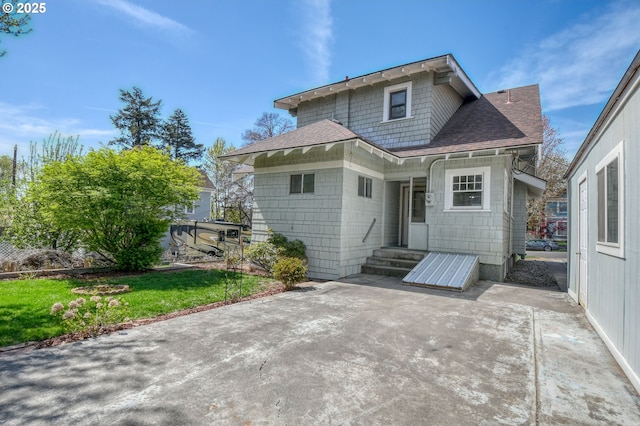 back of house featuring a patio and roof with shingles