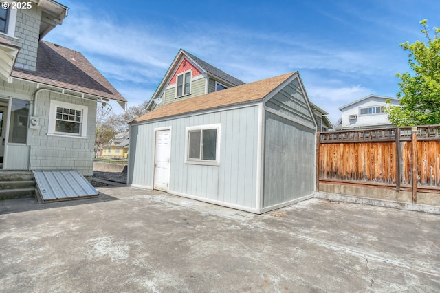view of outbuilding featuring an outdoor structure and fence