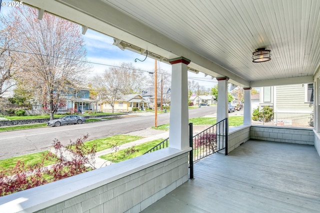 wooden deck featuring a residential view and covered porch