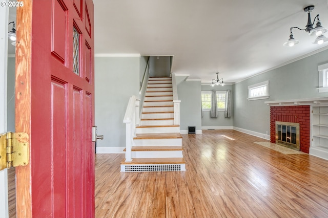 foyer with baseboards, stairway, a notable chandelier, and wood finished floors