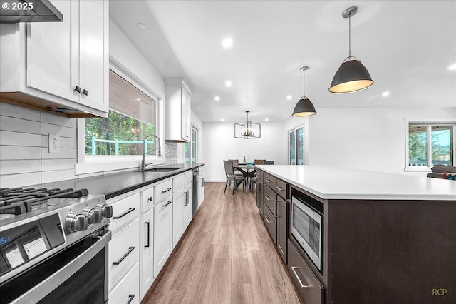 25125 SE Treehill Ln, Damascus, OR 97089 - kitchen featuring appliances with stainless steel finishes, recessed lighting, light wood-style flooring, backsplash, and white cabinetry