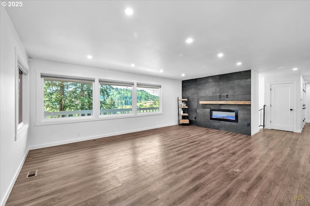 unfurnished living room with baseboards, recessed lighting, and a healthy amount of sunlight