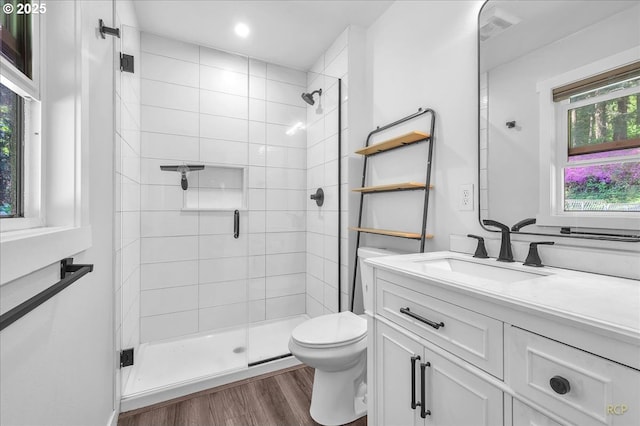 full bathroom with visible vents, a shower stall, wood finished floors, vanity, and toilet