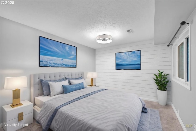carpeted bedroom with wooden walls, a textured ceiling, baseboards, and visible vents