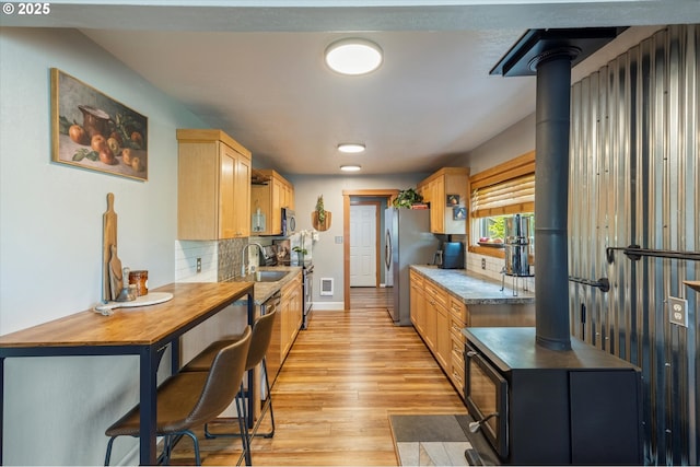332 26th Ave, Longview, WA 98632 - kitchen featuring a sink, decorative backsplash, light wood-style flooring, baseboards, and appliances with stainless steel finishes