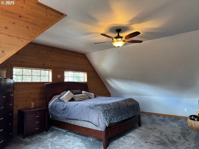 carpeted bedroom with vaulted ceiling, wood walls, and ceiling fan