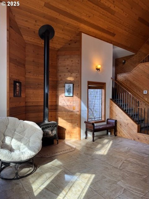 interior space featuring wood ceiling, wood walls, and a wood stove