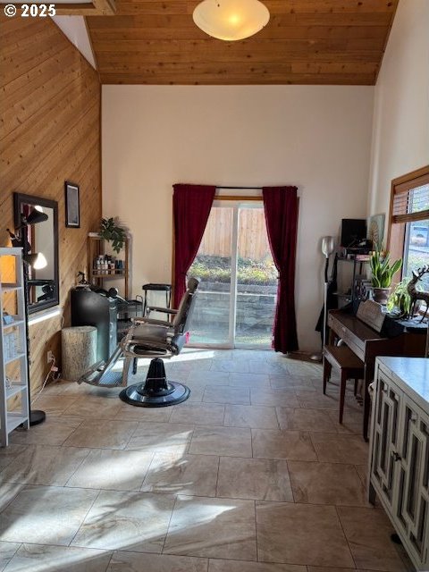 sitting room featuring high vaulted ceiling, wood ceiling, and wooden walls