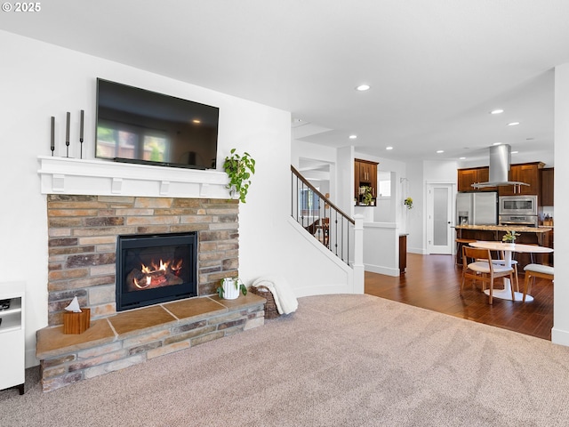15582 SE Owl Ln, Happy Valley, OR 97015 - living area featuring dark carpet, a fireplace, stairs, recessed lighting, and dark wood-style flooring