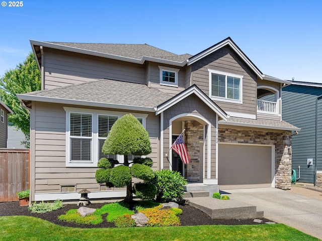 15582 SE Owl Ln, Happy Valley, OR 97015 - view of front of house featuring a garage, concrete driveway, roof with shingles, stone siding, and a balcony