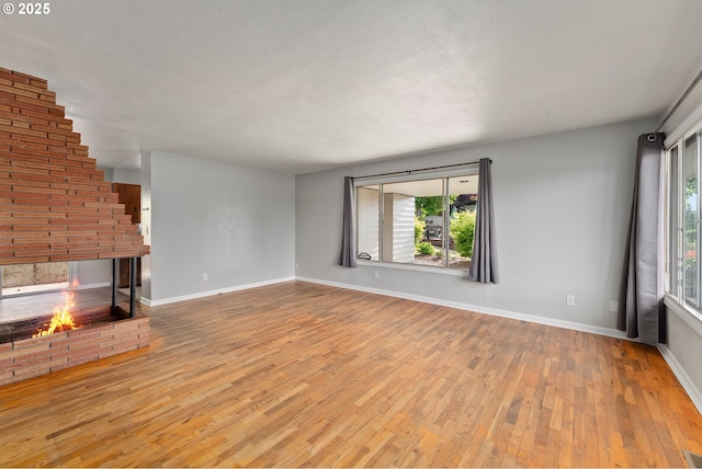 2431 W Crestview Ave, Roseburg, OR 97471 - unfurnished living room featuring hardwood / wood-style flooring, healthy amount of natural light, and a fireplace