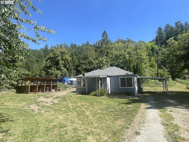 154 Decoy Ln, Myrtle Creek, OR 97457 - view of front of house featuring dirt driveway, a carport, a front yard, and a forest view
