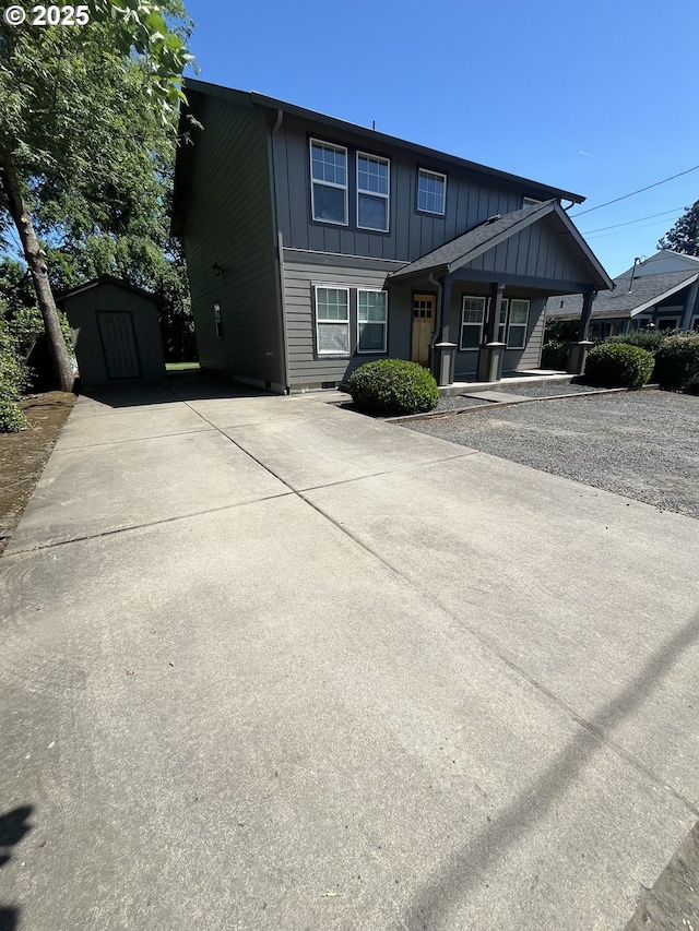 6721 N Yale St, Portland, OR 97203 - view of front of house with board and batten siding, a storage unit, covered porch, and driveway