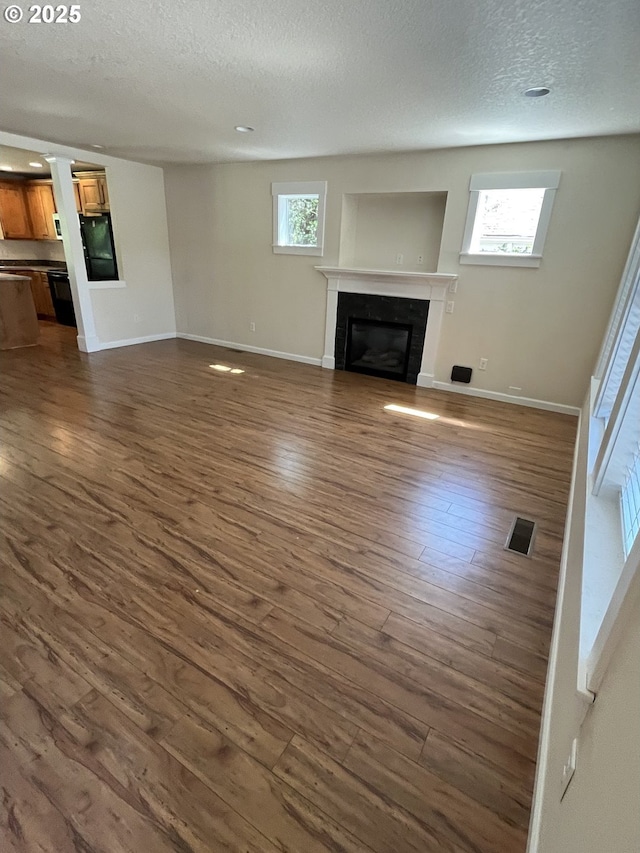 6721 N Yale St, Portland, OR 97203 - unfurnished living room featuring a textured ceiling, a glass covered fireplace, and dark wood-style flooring