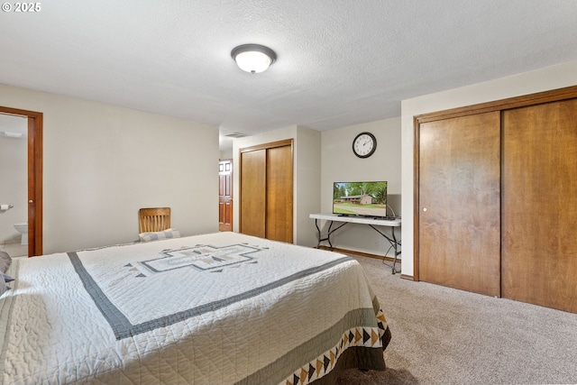 bedroom with multiple closets and carpet