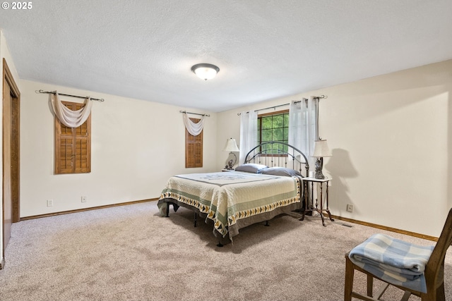 carpeted bedroom with baseboards and a textured ceiling