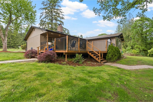 back of property featuring a chimney, a deck, stairway, and a lawn