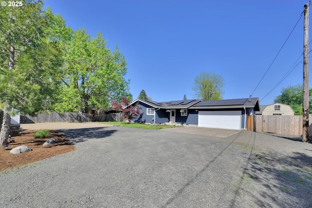 921 Williams St, Eugene, OR 97402 - ranch-style home featuring asphalt driveway, an attached garage, and roof mounted solar panels