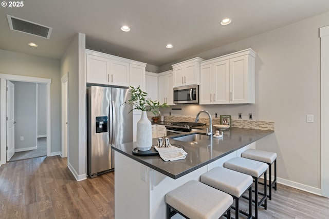 7314 NE 66th St, Vancouver, WA 98662 - kitchen with stainless steel appliances, a peninsula, a sink, baseboards, and a breakfast bar area