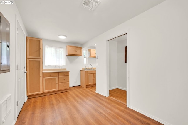 2801 Kincaid St, Eugene, OR 97405 - kitchen featuring light wood finished floors, a sink, light brown cabinetry, and baseboards
