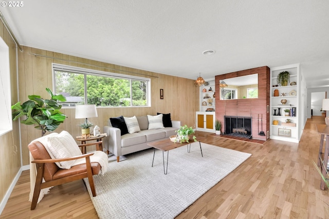 2801 Kincaid St, Eugene, OR 97405 - living area with light wood-style floors, wood walls, and a brick fireplace