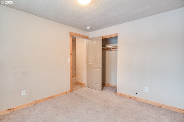 unfurnished bedroom featuring a closet, light carpet, and a textured ceiling