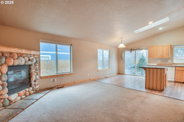 kitchen with a fireplace, decorative light fixtures, a kitchen bar, white dishwasher, and light carpet