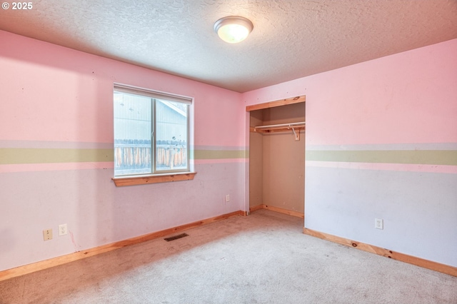 unfurnished bedroom with a closet, a textured ceiling, and carpet