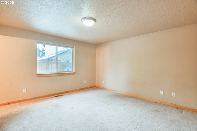 carpeted empty room with a textured ceiling