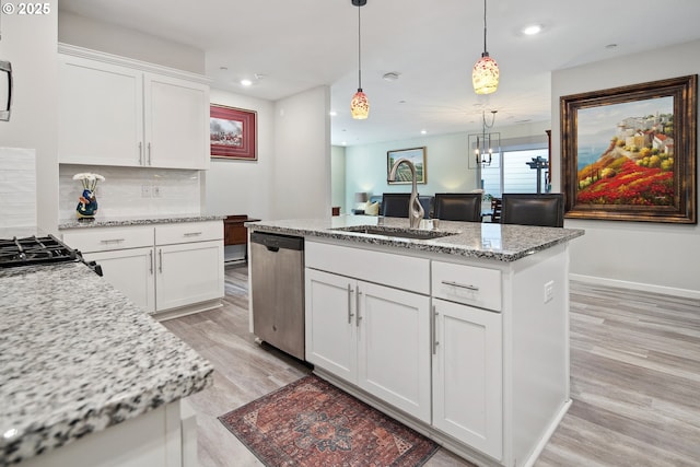 kitchen with tasteful backsplash, a center island, stainless steel dishwasher, white cabinetry, and a sink