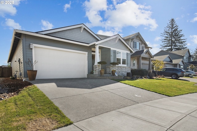 craftsman-style house featuring a front lawn, driveway, stone siding, a residential view, and a garage