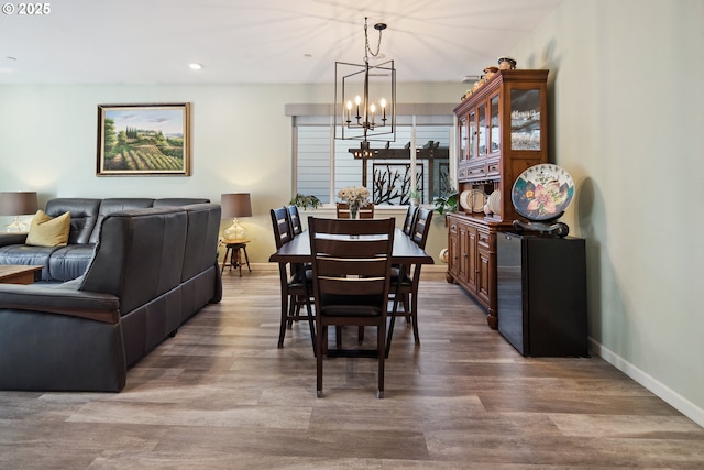 dining space featuring recessed lighting, a notable chandelier, wood finished floors, and baseboards